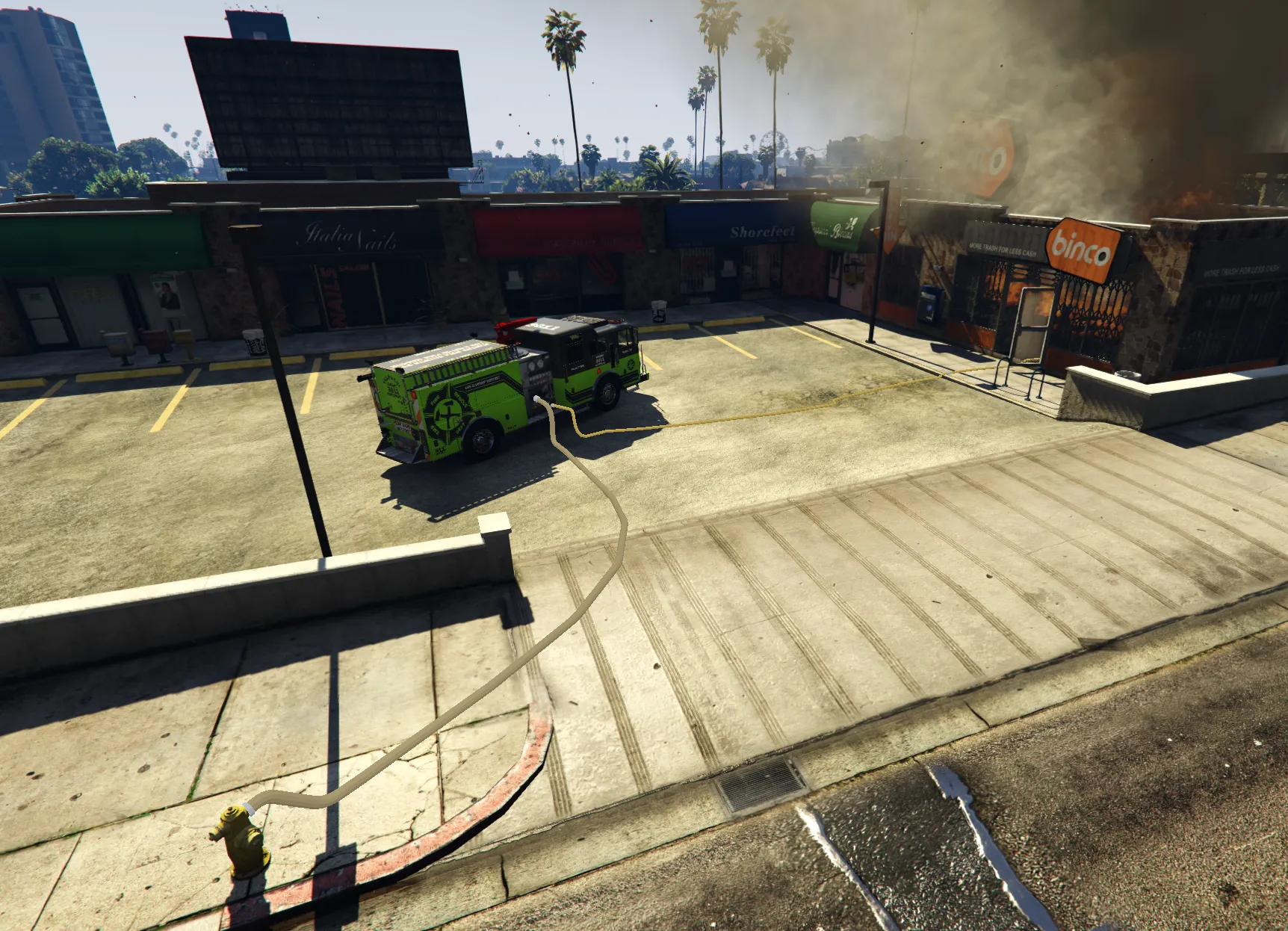Wide view of a Broken Compass fire scene showing a hydrant, fire engine, deployed hoses, and an active building fire.